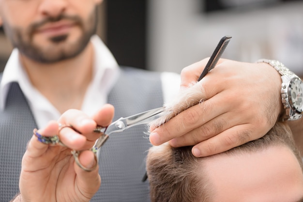 Foto de peluquero trabajando con cliente en barbería.