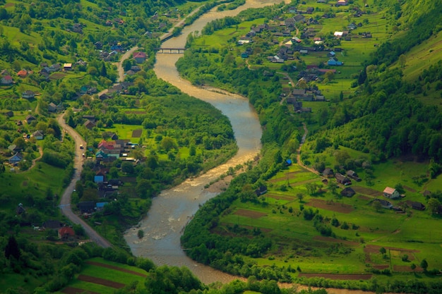 Foto de un pequeño pueblo entre las montañas y el río.