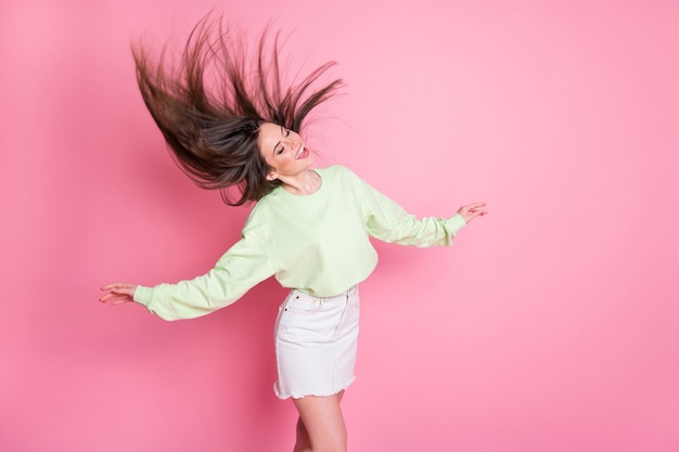 Foto de perfil de una atractiva dama milenaria divertida bailando estudiantes fiesta peinado vuelo aire libertad ropa casual crop pullover falda de jeans de vientre desnudo aislado fondo de color rosa