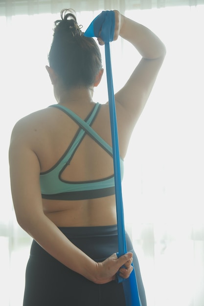 Foto foto de perfil de una hermosa y segura mujer de buen estado físico con un atuendo atlético gris haciendo ejercicios de escalador de montaña en su luminoso y espacioso apartamento con un acogedor interior minimalista