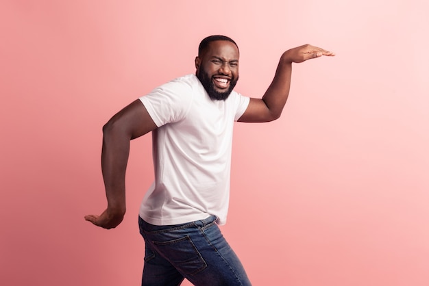 Foto de perfil de hombre cobarde tiene tiempo libre bailando sobre fondo rosa