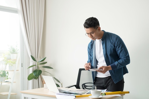 Foto de perfil de un joven arquitecto trabajando en planos en su escritorio en la oficina copyspace planes de construcción ingeniero de proyectos de construcción experto especialista ocupación laboral calificada