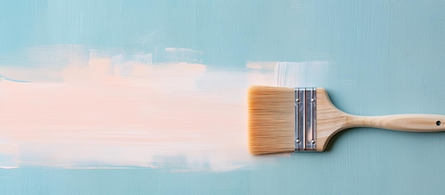 Foto de un pincel con pintura blanca en una pared azul con mucho espacio vacío para el texto