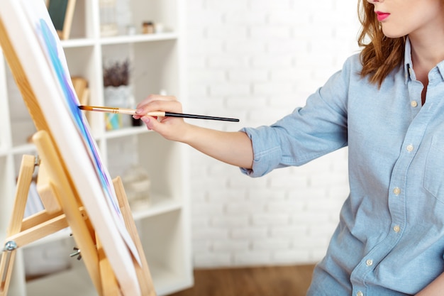 Foto de pintura de joven artista femenina en estudio