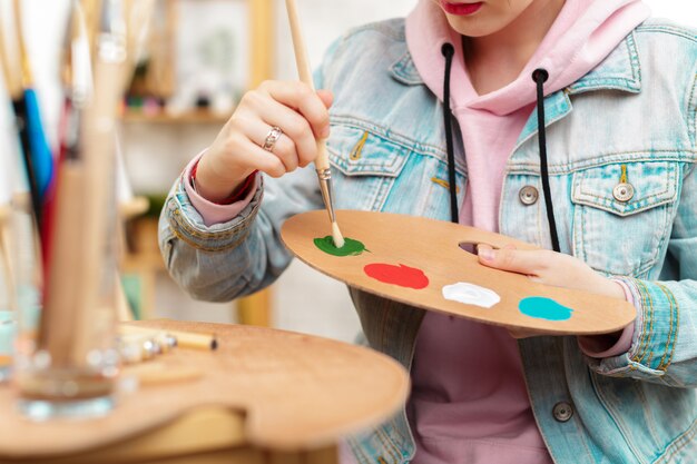 Foto de pintura de joven artista femenina en estudio