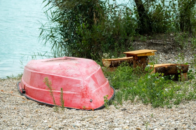 Foto de playa con bote rojo y asiento.