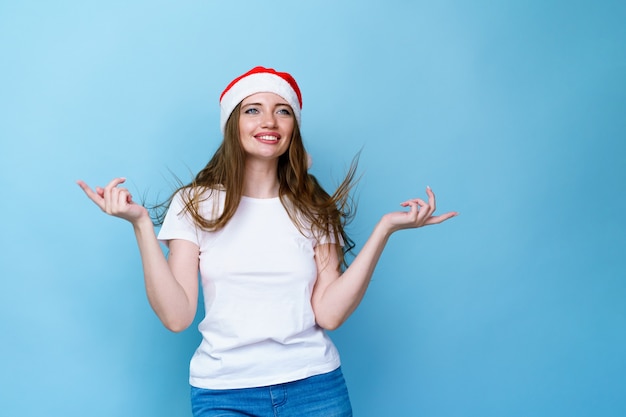 Foto positiva garota com chapéu de Papai Noel segurar a mão demonstrar anúncio de ano novo de Natal promo ...