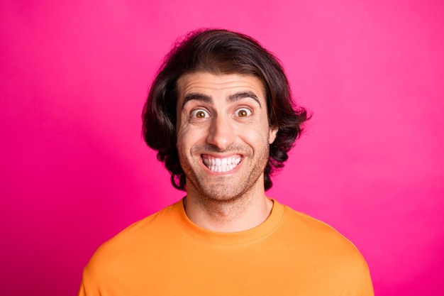 Foto de positivo joven sonrisa blanca excitado divertido desgaste camiseta naranja aislado fondo de color rosa