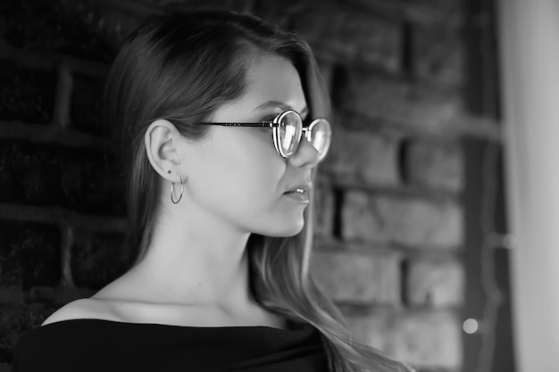 foto preto e branco de uma garota de óculos/retrato clássico de garota de óculos de um conceito estrito de empresária
