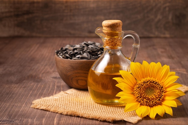 Foto del primer del aceite de girasol con las semillas en fondo de madera. Concepto de producto bio y orgánico.