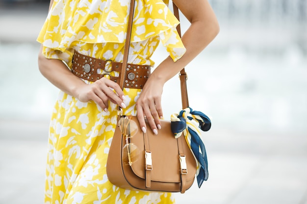 Foto foto de primer plano de accesorios de mujer. monedero, gafas de sol y el pañuelo. bolso marrón con detalles de moda.