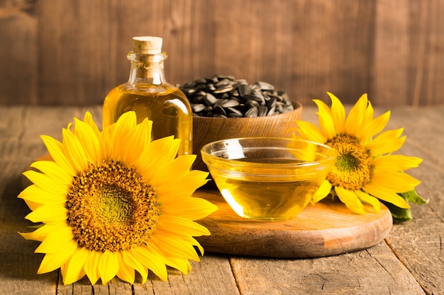 Foto de primer plano de aceite de girasol con semillas en la mesa de madera. Concepto de producto bio y orgánico.