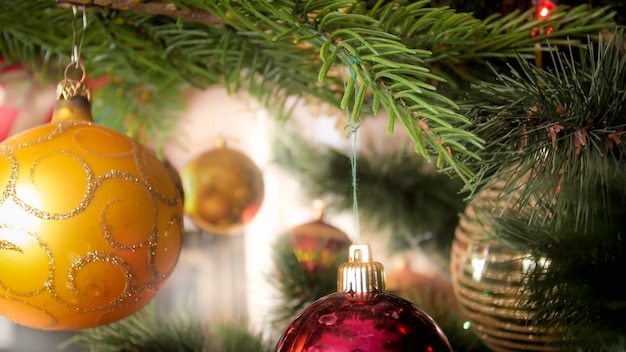 Foto en primer plano de adornos de oro colgando de un árbol de Navidad decorado