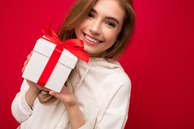 Foto en primer plano de la atractiva mujer joven rubia sonriente feliz aislada sobre fondo de colores