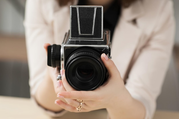 Foto foto de primer plano de cámara retro en mano femenina equipo de fotografía negro con zoom de mango