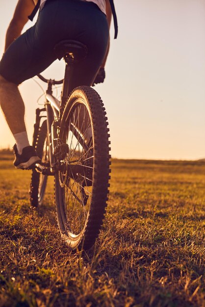 Foto de primer plano de un ciclista montando en bicicleta en la cima de una montaña