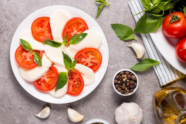 Foto de primer plano de ensalada caprese con tomates maduros albahaca mozzarella de búfala queso italiano y yo