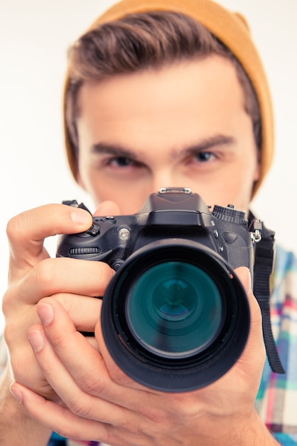 Foto foto en primer plano de un fotógrafo con sombrero tomando una foto