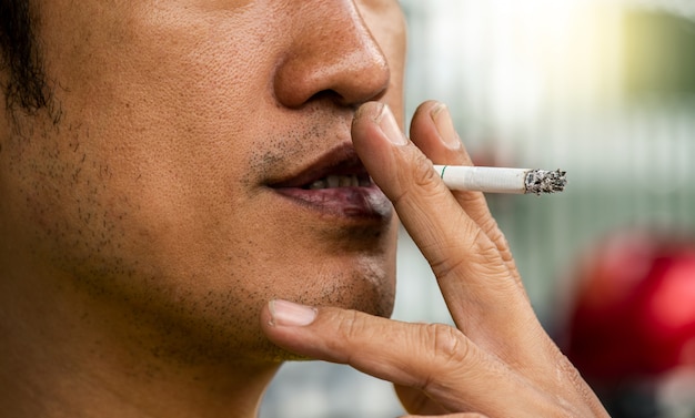 Foto foto de primer plano del hombre fumando con sucio