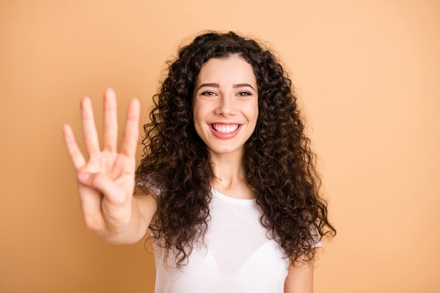 Foto en primer plano de la increíble dama levantando la mano mostrando cuatro dedos comenzando la cuenta regresiva usar traje casual blanco aislado fondo de color beige pastel