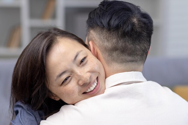 Foto de primer plano joven pareja asiática familia abrazándose juntos cara feliz de mujer joven abrazando y