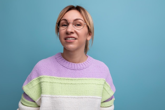 Foto de primer plano de una linda y atractiva mujer rubia con un suéter a rayas con gafas para ver en un