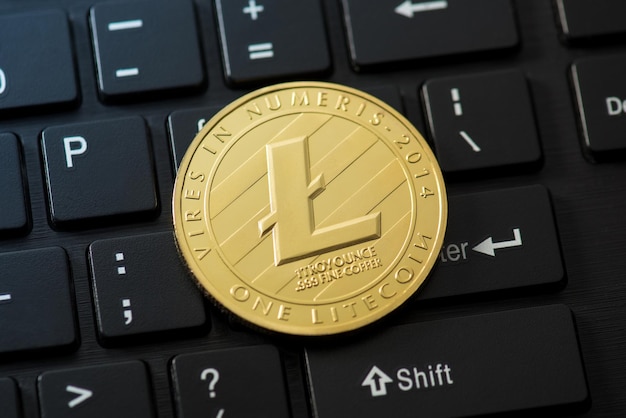 Foto de primer plano de la moneda de oro con el símbolo de litecoin en el fondo del teclado negro