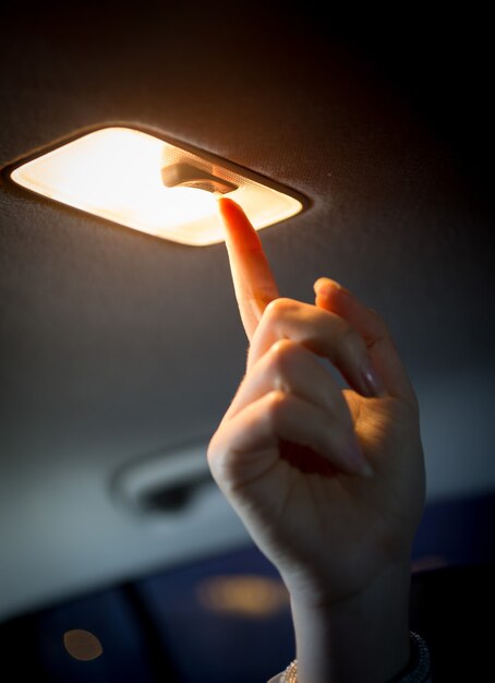 Foto foto en primer plano de la mujer encendiendo la luz en el salón del automóvil