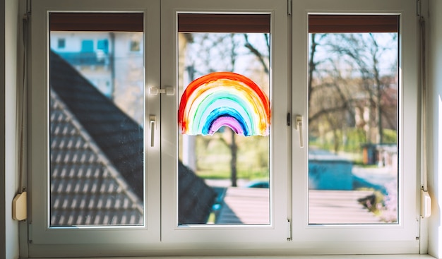 Foto en primer plano de la pintura arco iris en la ventana