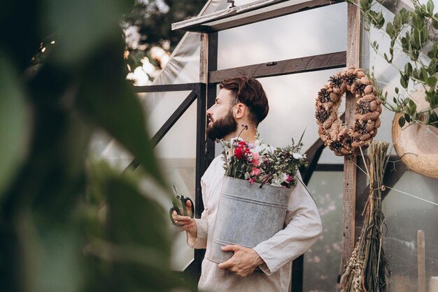 Foto del proceso de trabajo del florista en una finca de flores donde cultiva flores El dueño de una finca de flores riega y corta flores para la venta