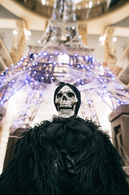 Foto foto próxima de um esqueleto de uma mulher em roupas escuras em uma sala decorativa para o halloween
