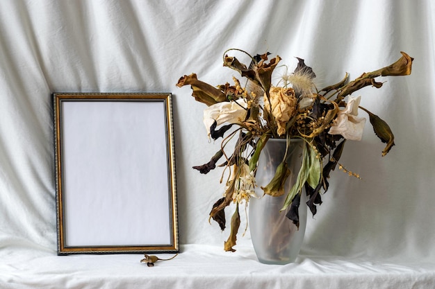 Foto-Rahmen-Mockup mit getrockneten trockenen Blumen in einer Vase Stillleben auf einem hellen Hintergrund