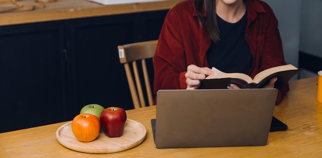 Foto recortada da mulher asiática de negócios freelancer segurando a xícara de café e fazendo o planejamento, analisando o relatório financeiro, plano de negócios, investimento, análise financeira, local de trabalho