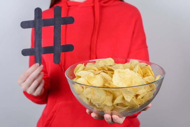 Foto recortada de close-up de pessoas atraentes alegres e animadas segurando grandes e saborosas batatas fritas com fundo cinza isolado nas mãos