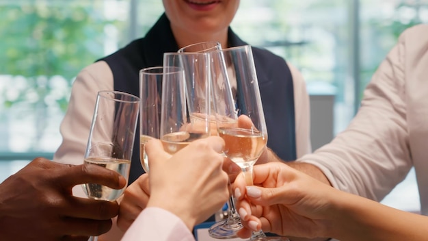 Foto recortada de colegas de trabalho brindam com taças de champanhe para comemorar o sucesso