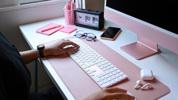 Foto recortada de designer feminina trabalhando com computador no local de trabalho criativo