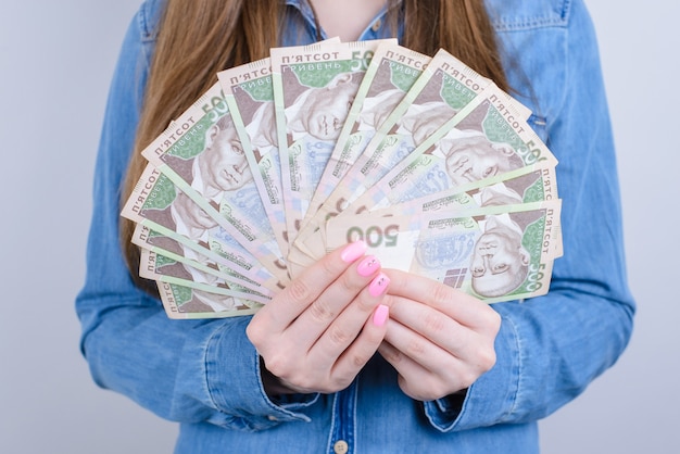 Foto recortada de dinheiro ucraniano segurando nas mãos a bela senhora isolada de fundo cinza