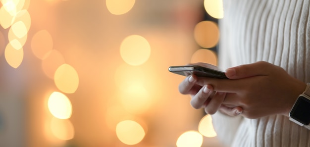 Foto recortada de empresária segurando a tela em branco com luz de bokeh