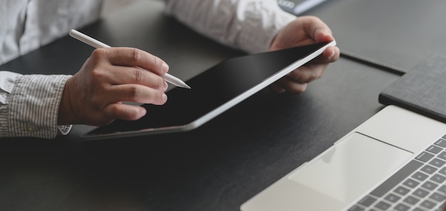 Foto recortada de empresário de sucesso, trabalhando em seu projeto com tablet