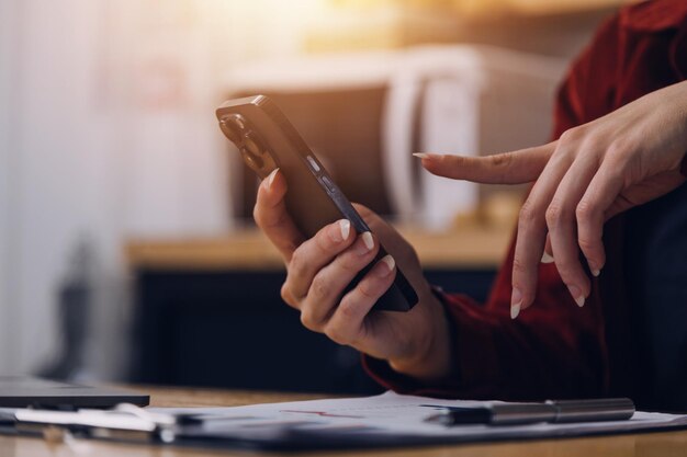 Foto recortada de freelancer de negócios mulher asiática segurando xícara de café e fazendo planejamento analisando o relatório financeiro plano de negócios análise de financiamento de investimento no local de trabalho