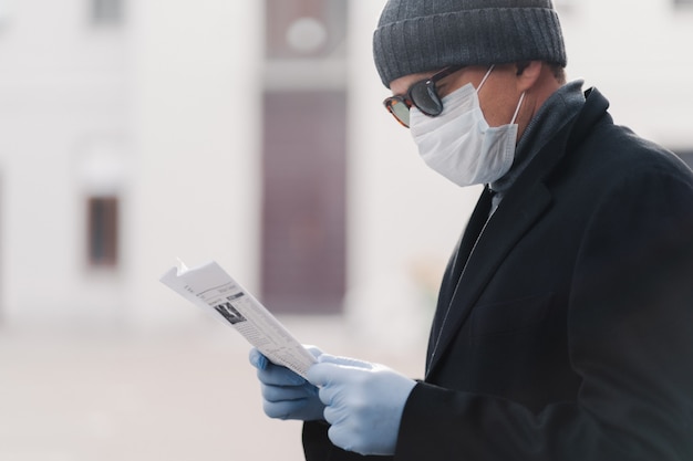 Foto recortada de homem usa máscara médica facial e luvas de borracha protetora