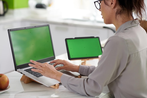 Foto recortada de jovem freelancer digitando no teclado do laptop