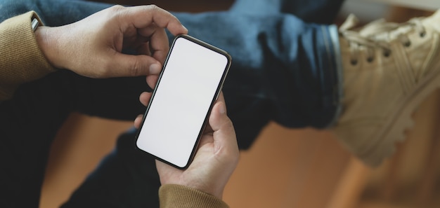 Foto recortada de jovem segurando o smartphone de tela em branco