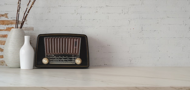 Foto recortada de local de trabalho vintage com decorações vintage de rádio e vaso na mesa de mármore