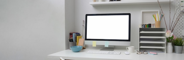 Foto recortada de mesa de escritório simples com computador de tela em branco na mesa branca