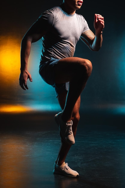 Foto recortada de um esportista aquecendo os músculos e colocando um joelho para cima