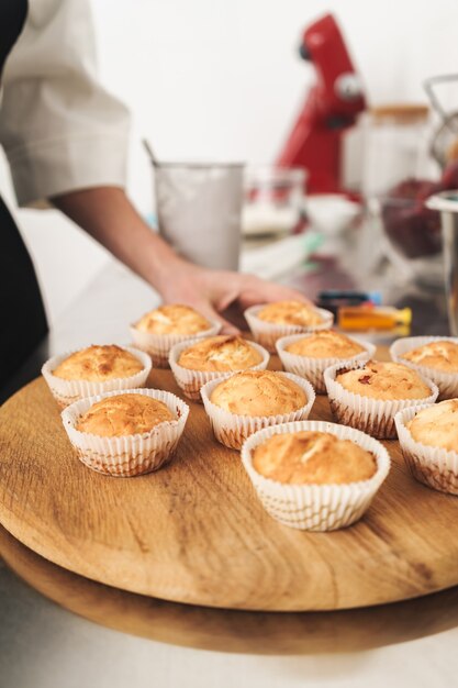 Foto recortada de um jovem e bonito cozinheiro chefe na cozinha cozinhando doces dentro de casa.