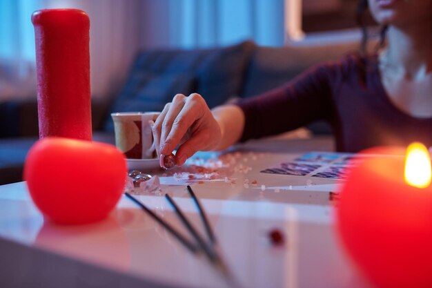 Foto recortada de um leitor de cartas de tarô pegando uma pequena bola de cristal da mesa de adivinhação