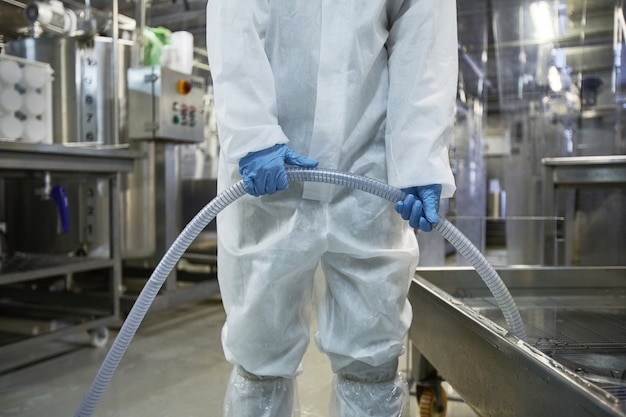 Foto recortada de um trabalhador irreconhecível lavando equipamentos em uma fábrica de produção de alimentos limpos, copie o espaço