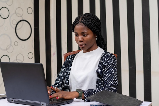 Foto recortada de uma linda garota africana usando um laptop